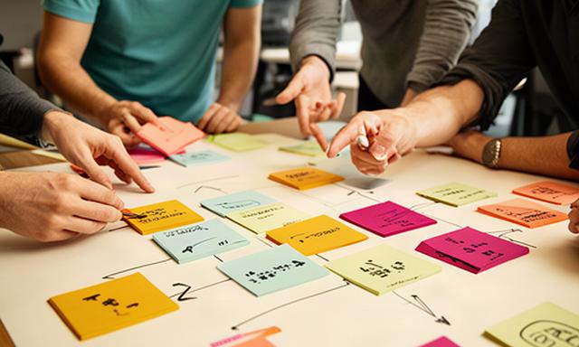 Teamleden van een snelgroeiend bedrijf werken met gekleurde notities aan KPI-keuzes tijdens een workshop